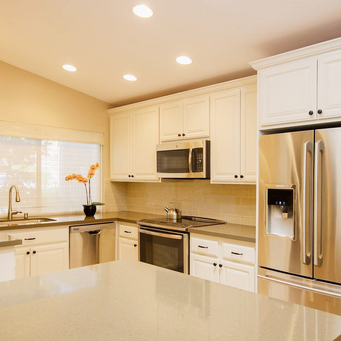 After Photo of Remodeled Kitchen with White Painted Cabinets, Stainless Steel Appliances and Quartz Countertops